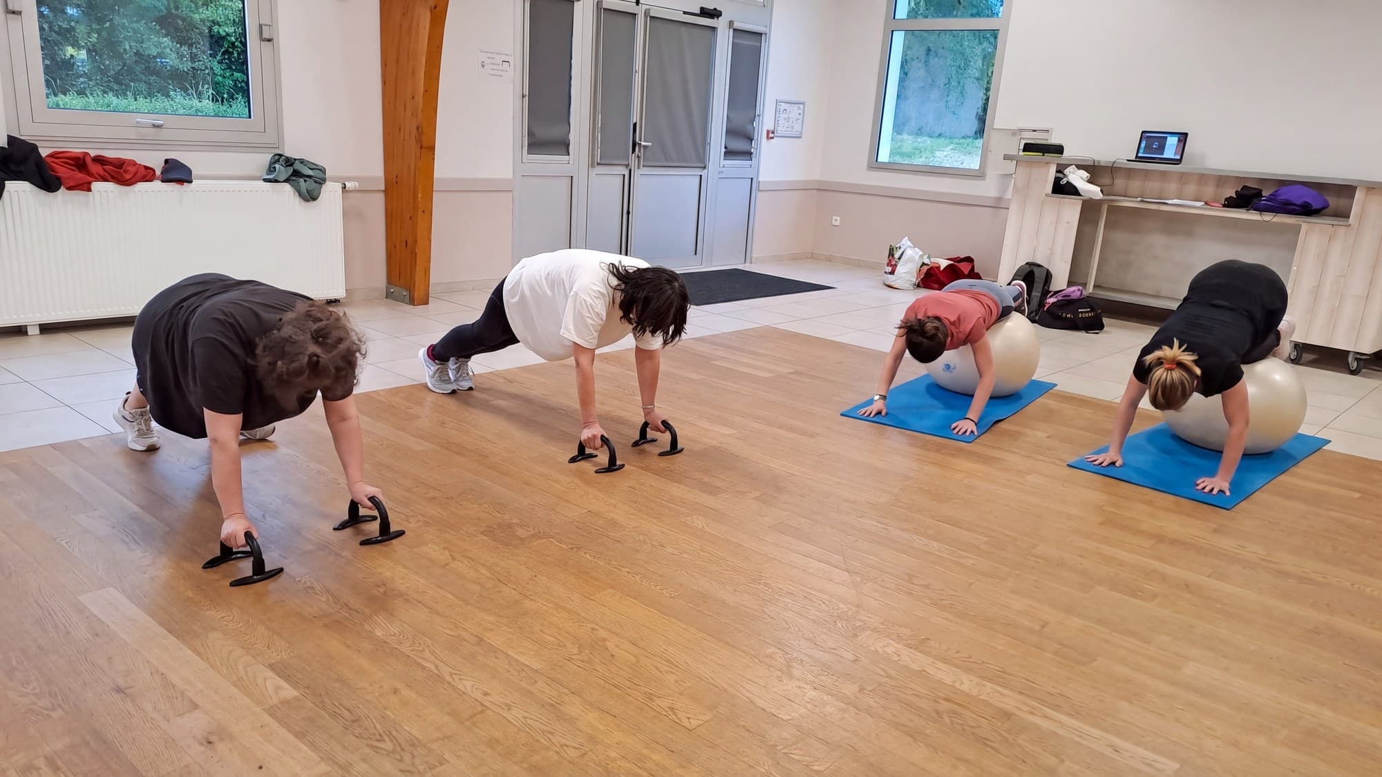 Quatre adhérentes en gainage, deux sur poignées de pompes, deux sur ballon.