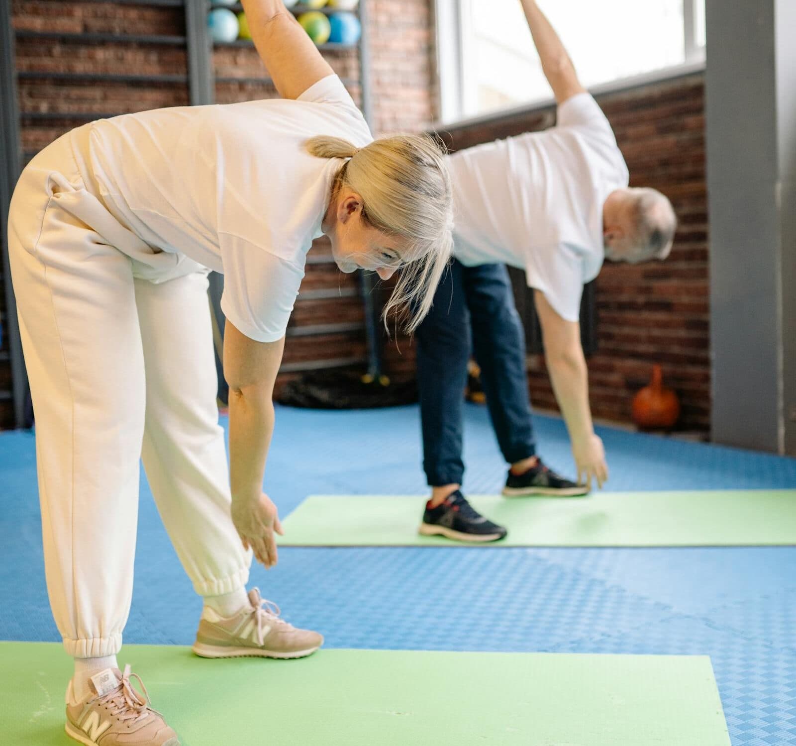 Séance en salle au club Brain Fitness, étirements sur tapis.